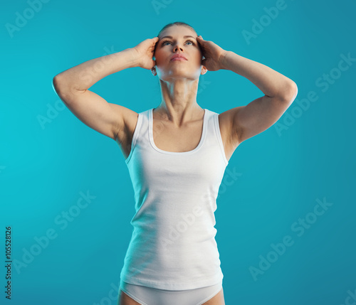 Woman training neck muscles over blue background. Relaxation and rehabilitation concept. 