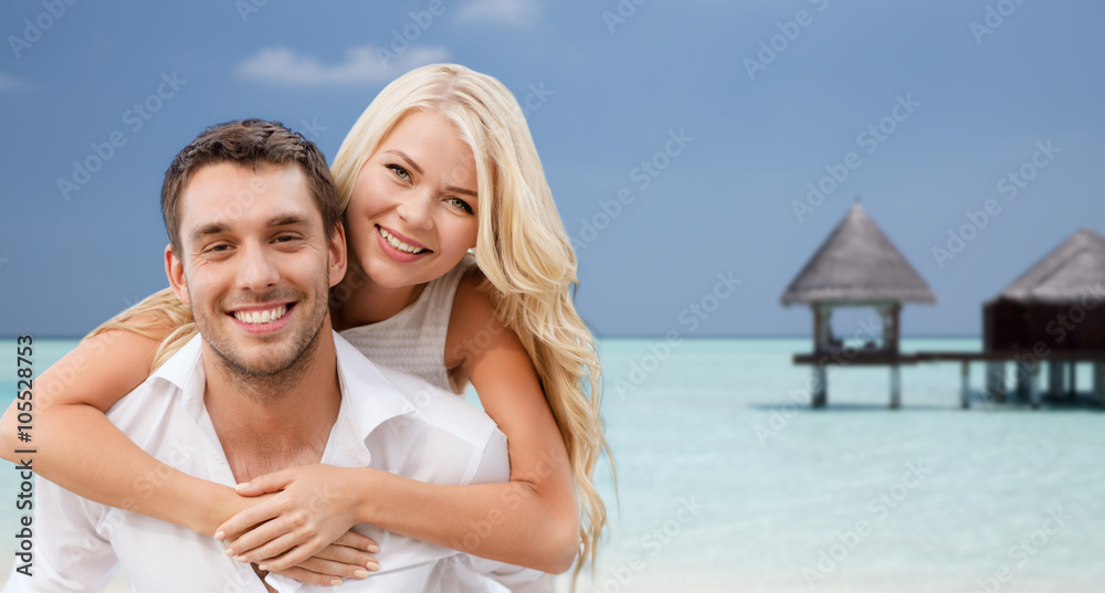 happy couple having fun over beach with bungalow