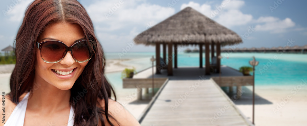 smiling young woman with sunglasses on beach