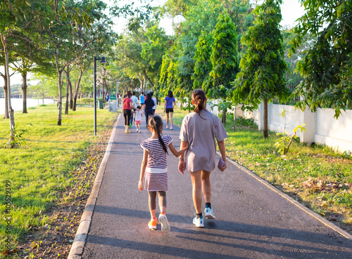 couple of mother and daughter running together in park
