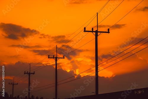 Silhouette electricity post with beautiful sunset background. © nuttawutnuy