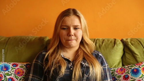 Sad woman sitting on couch in house 
 photo