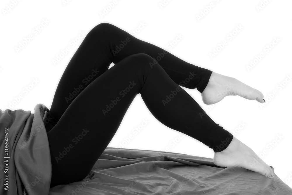 woman legs in black tight pants barefoot knees up Stock Photo