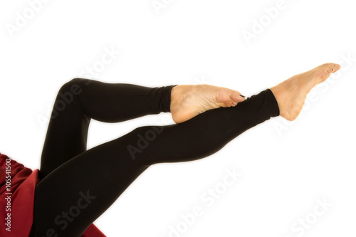 woman legs in black tight pants barefoot foot on shin