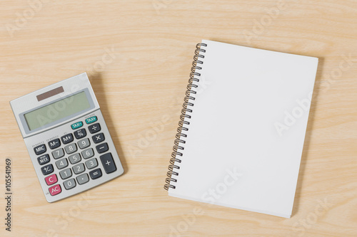 notebook with calculator on wood table