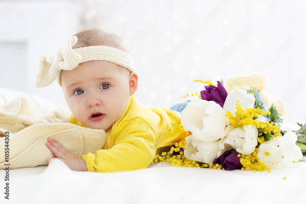 Baby girl in bed with spring flowers Baby girl in bed with spring flowers