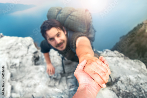 adventurers helping each other to climb the mountain