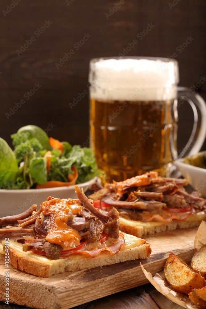 Sandwich with shredded pork, roasted potatoes and salad Sandwich with shredded pork, roasted potatoes and salad