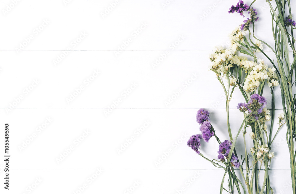 Bouquet of dried wild flowers on white table background with natural wood vintage planks wooden texture top view horizontal, empty space for publicity information or advertising text