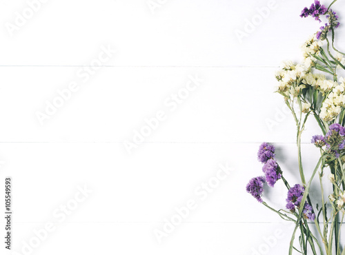 Bouquet of dried wild flowers on white table background  with natural wood vintage planks wooden texture top view horizontal, empty space for publicity information or advertising text