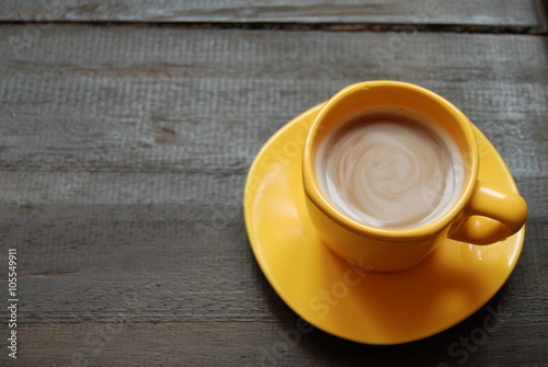 Instant Hot Coffee in yellow cup on dark brown background. Close-up, view from above.