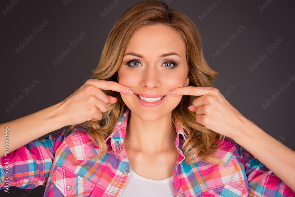 Portrait of happy young woman posing with streched smile Portrait of happy young woman posing with streched smile