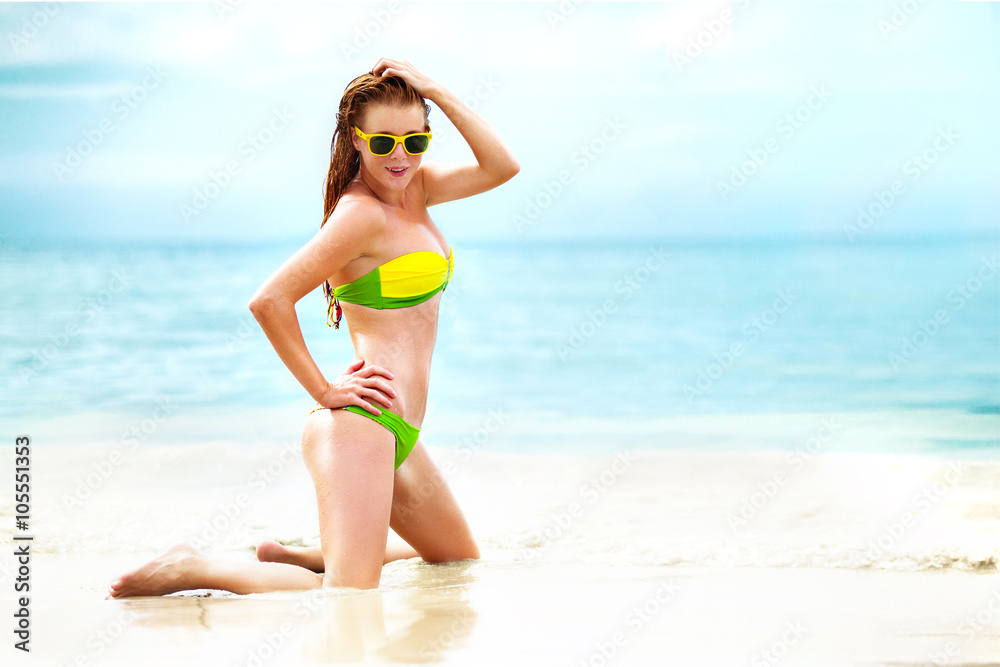 portrait of woman in yellow swim posing on tropical beach