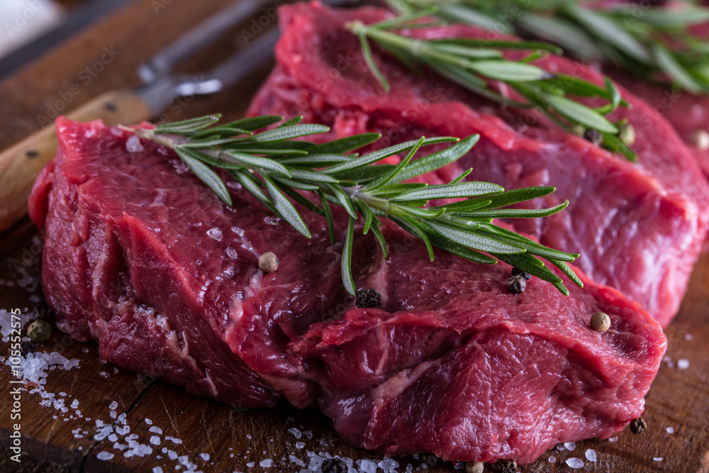 Steak. Raw beef steak. Fresh raw Sirloin beef steak sliced or whole ready for BBQ or grill. Herb - Rosemary decoration.