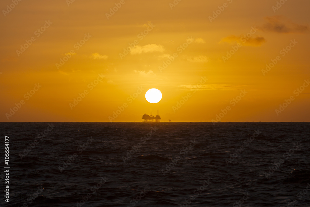 Silhouette of a drilling rig at sunset
