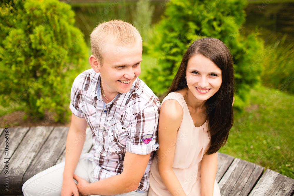 Young hip couple laughing on bench in the park Young hip couple laughing on bench in the park