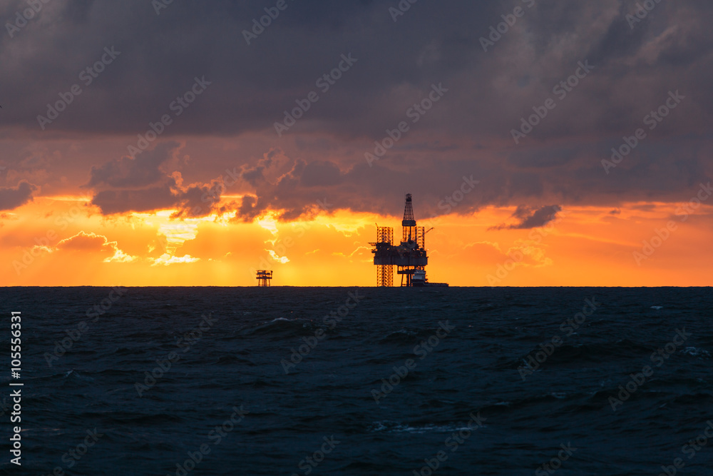 Silhouette of a drilling rig at sunset