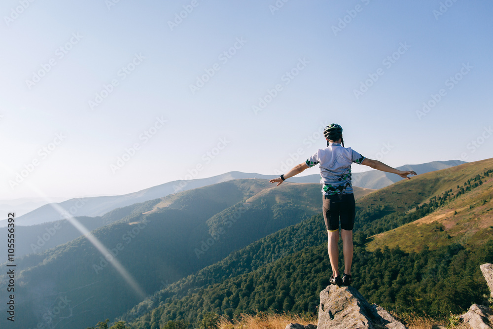 Naklejka premium biker man jumps from the cliff in mountains