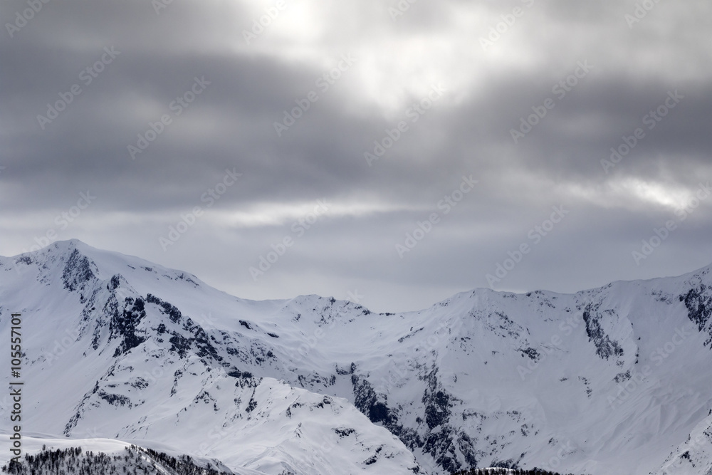 Snowy mountains and gray sky before blizzard