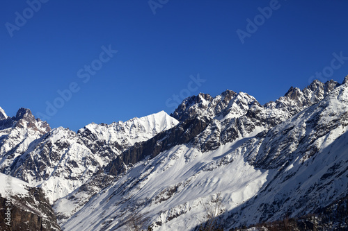 View on snowy rocks and blue clear sky at nice sun day