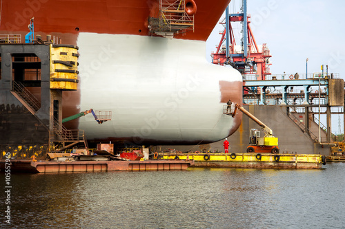 Painting the hull of the ship at the dock during the renovation in Gdansk Repair Shipyard