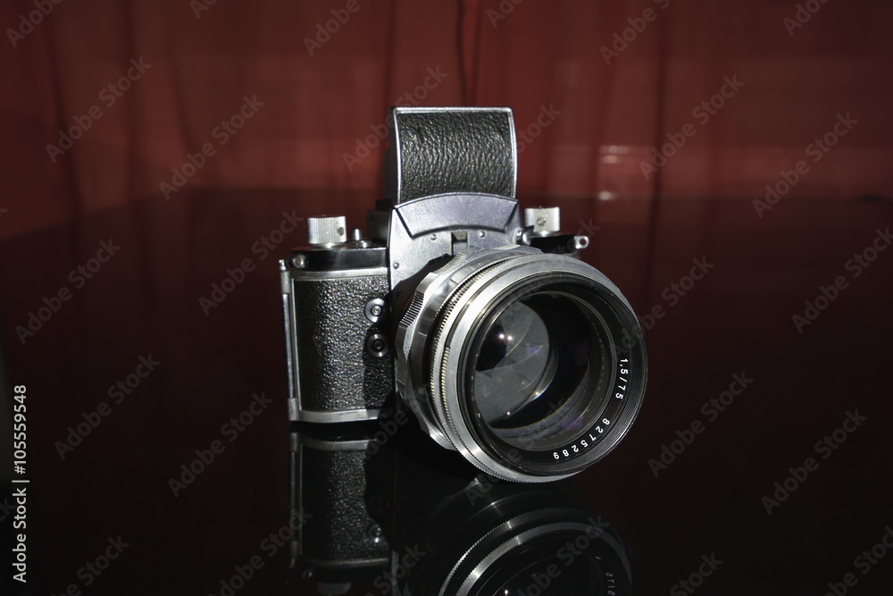 Old analogue manual vintage german SLR camera for 35 mm film isolated on the black background with old german portrait lens made in Jena city. One of the best post war cameras and lenses in the world.
