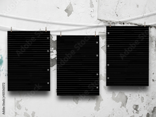 Slika na platnu Close-up of three hanged blank black paper sheet frames with pegs against grey w