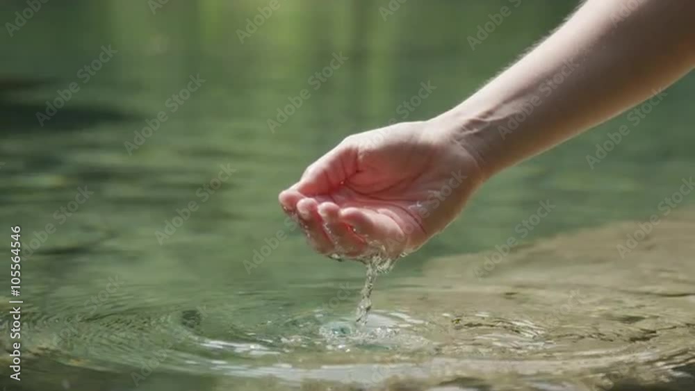 SLOW MOTION CLOSEUP: Hand holding and pouring fresh water