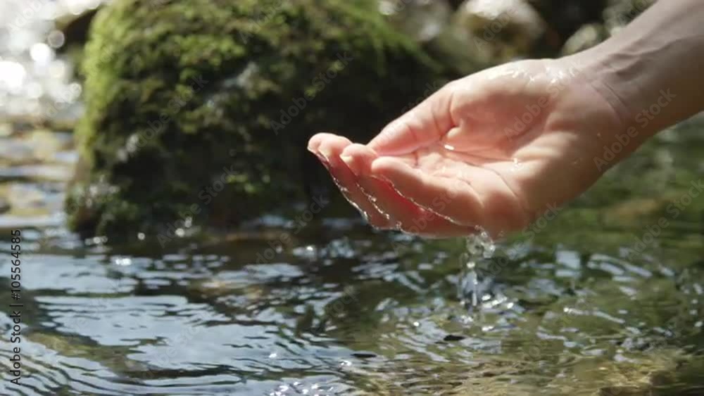 SLOW MOTION: Hand scooping fresh water in pure mountain spring