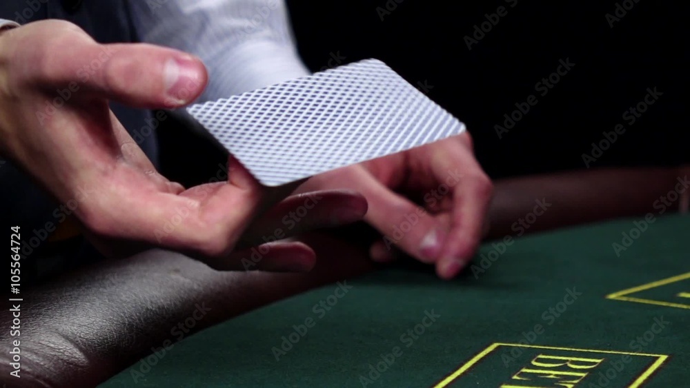 Croupier twisting card, shows one on green table, slow motion