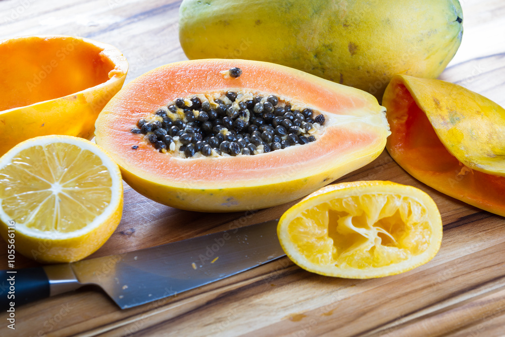 Papaya cut in half served with lemon Papaya cut in half served with lemon