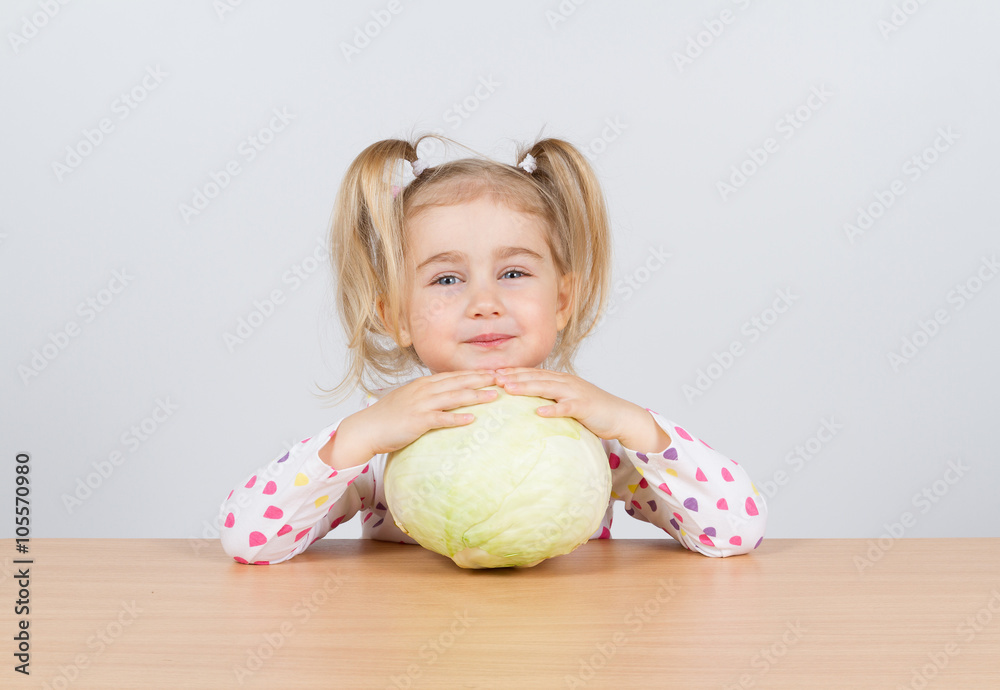 Fototapeta premium Little girl holding forks of cabbage.