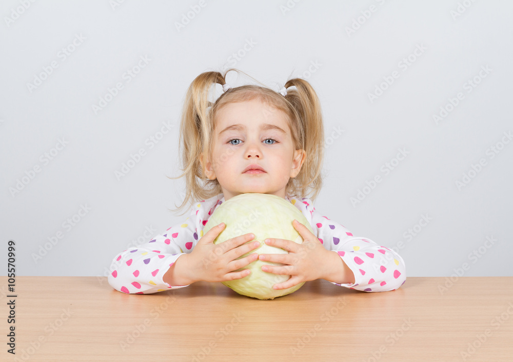 Fototapeta premium Little girl holding forks of cabbage.