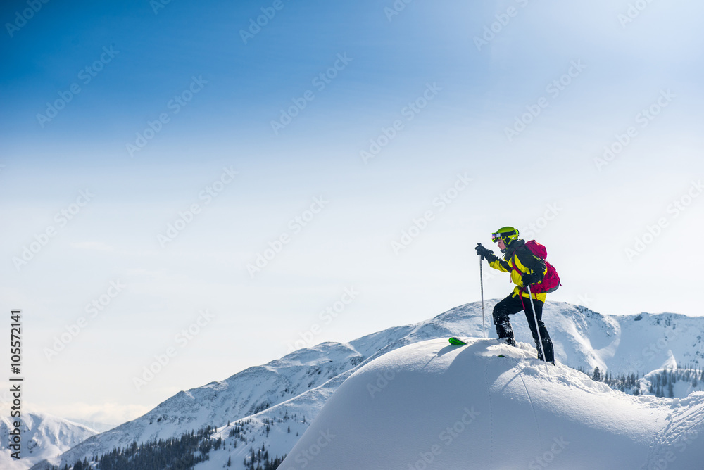 Skier walking on top of the mountain.