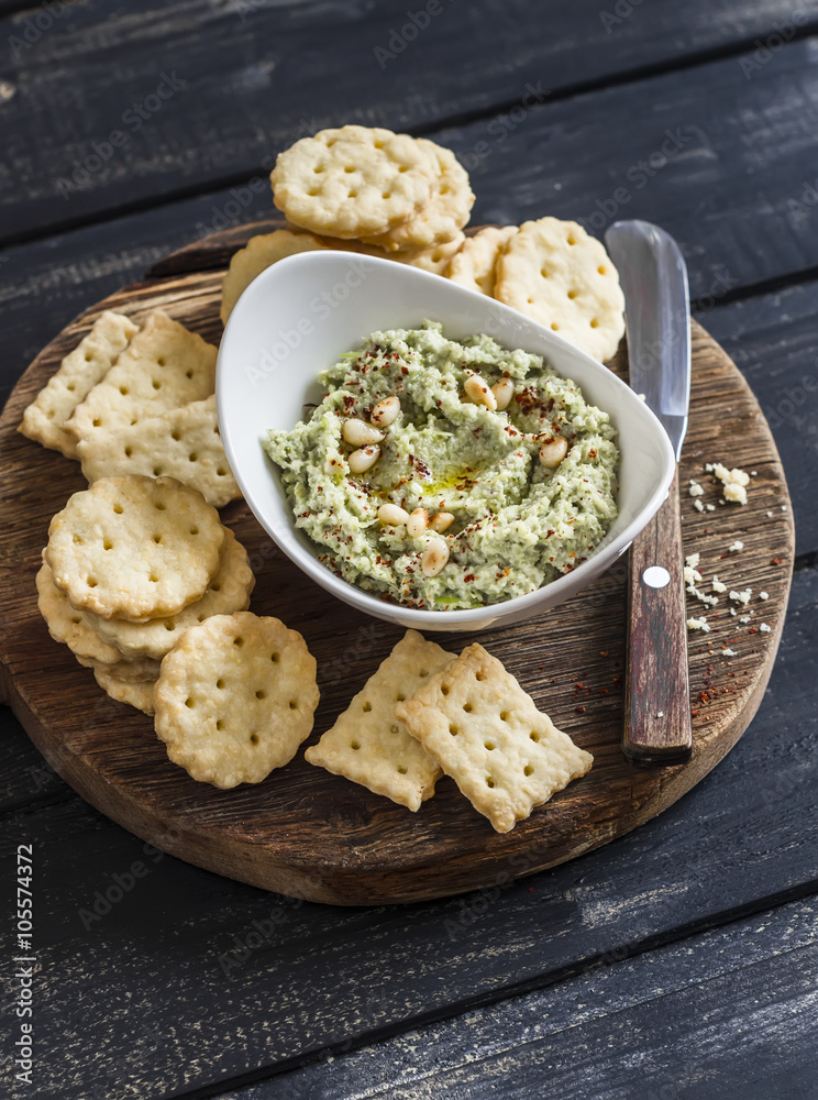 Healthy vegetarian broccoli and pine nuts hummus and homemade cheese biscuits on a wooden rustic board. Delicious snack or appetizer with wine Healthy vegetarian broccoli and pine nuts hummus and homemade cheese biscuits on a wooden rustic board. Delicious snack or appetizer with wine