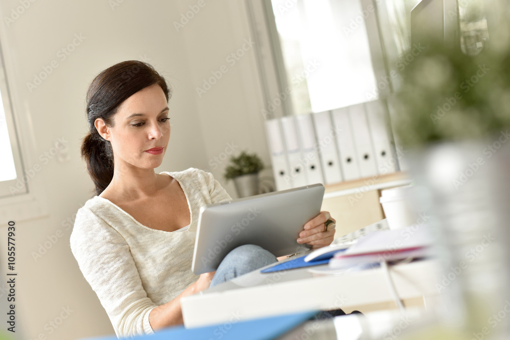 Businesswoman in office working on digital tablet Businesswoman in office working on digital tablet