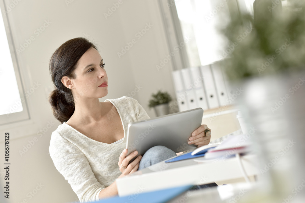 Businesswoman in office working on digital tablet Businesswoman in office working on digital tablet