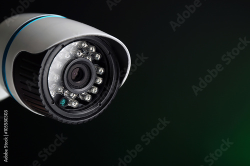 Security CCTV camera on green background, closeup