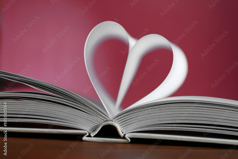 Heart from book pages on red blurred background Heart from book pages on red blurred background