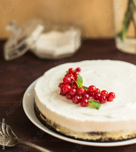 yoghurt cake with currants on wooden background