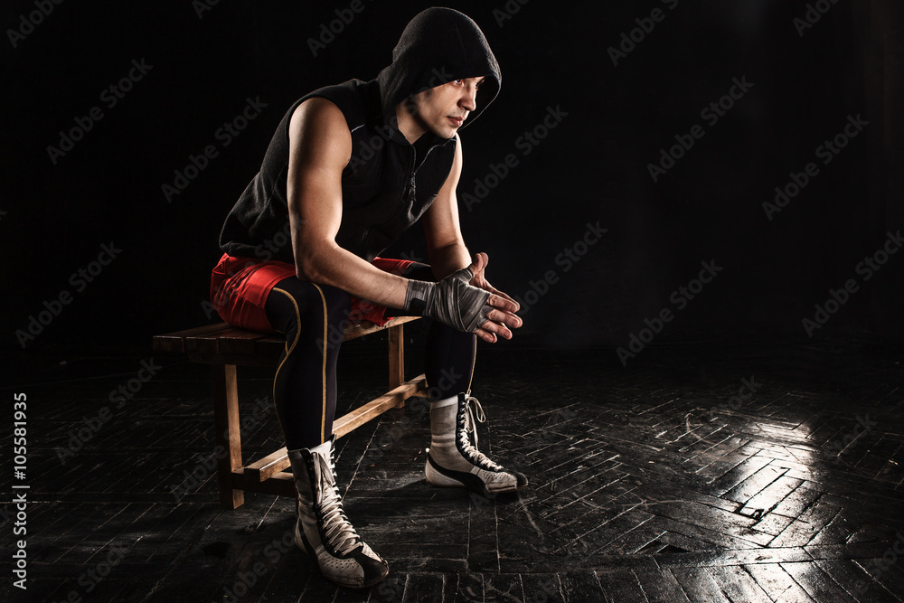 The muscular man sitting and resting on black The muscular man sitting and resting on black