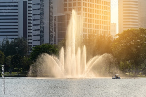 Beautiful fountain in urban lake with closeup building backgroun