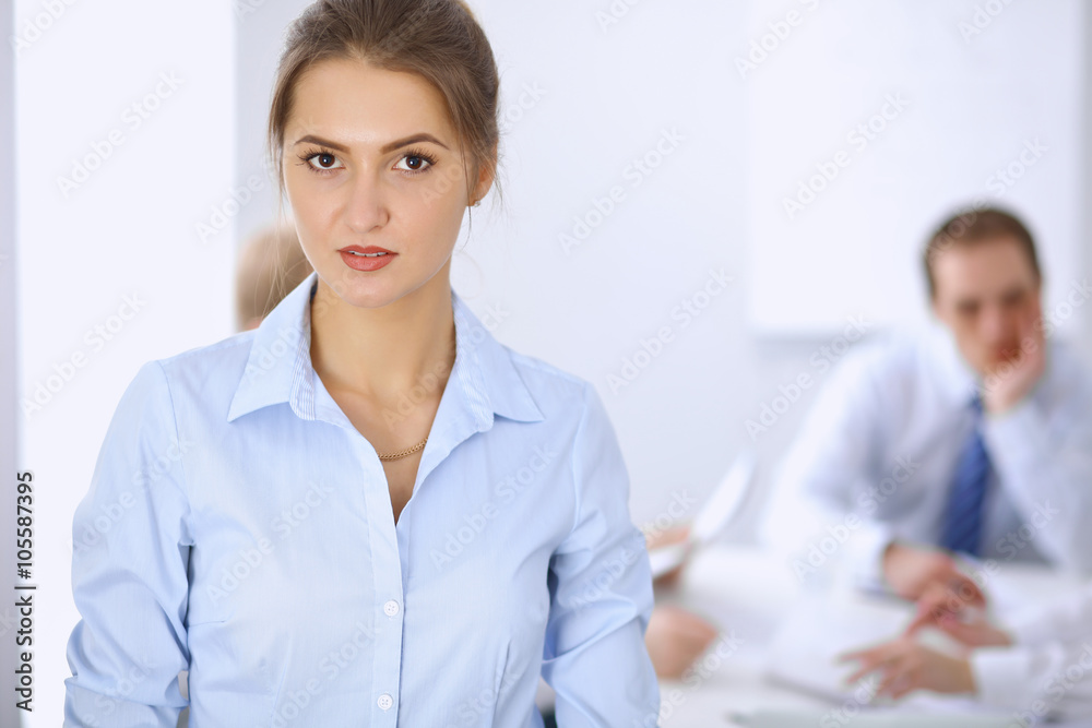 Fototapeta premium Beautiful business woman on the background of business people during meeting