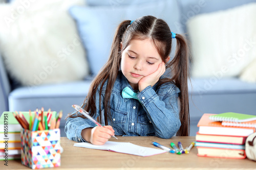 Little girl writing with pe...