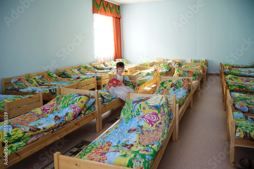 Фотография Beautiful girl sitting with a card in his hand on one of the bed