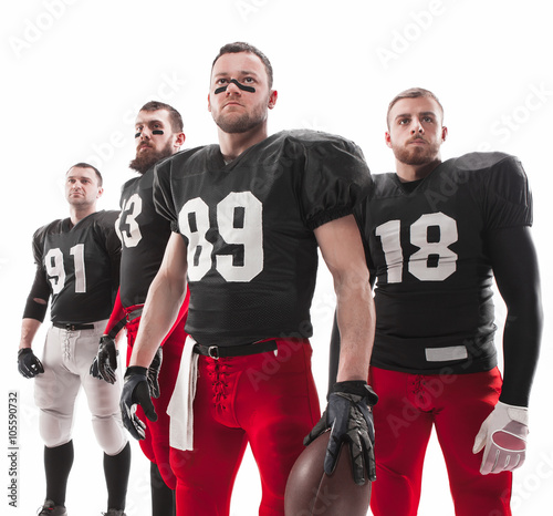 The four american football players posing with ball on white background