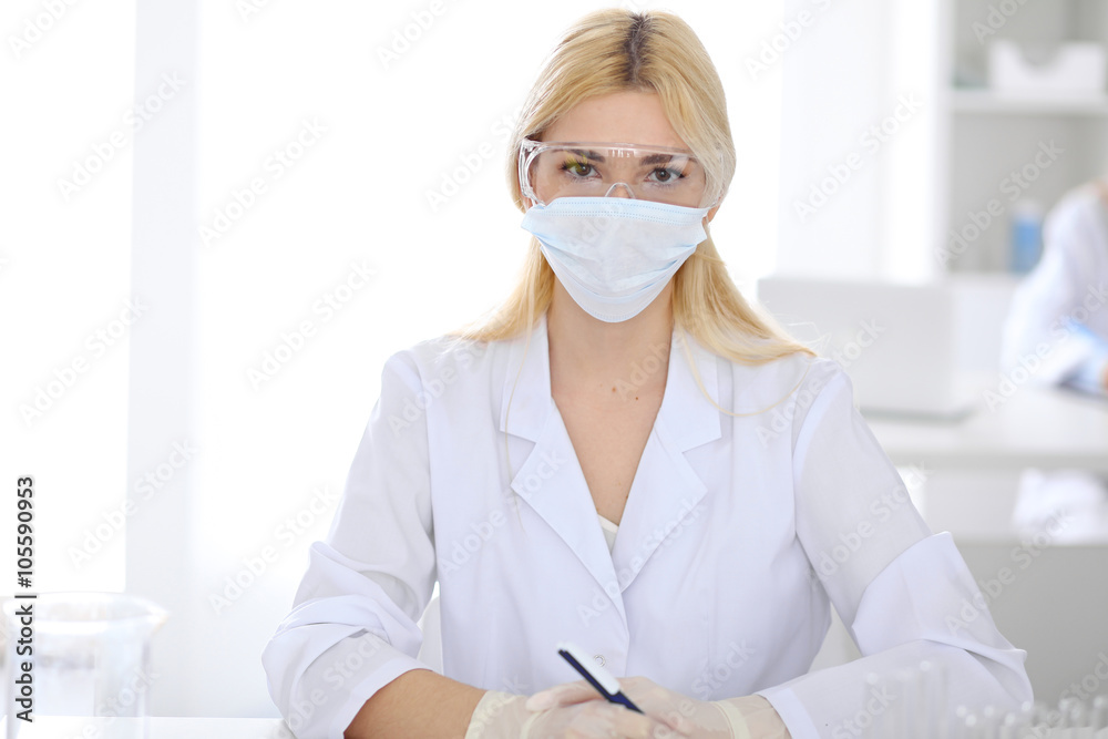 Female scientific research team with clear solution in laboratory Female scientific research team with clear solution in laboratory