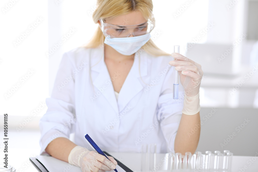 Female scientific research team with clear solution in laboratory Female scientific research team with clear solution in laboratory