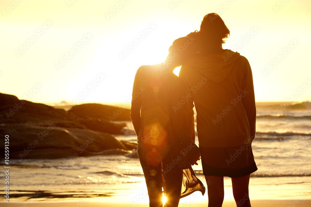 Loving couple holding hands at the beach watching the sunset Stock ...