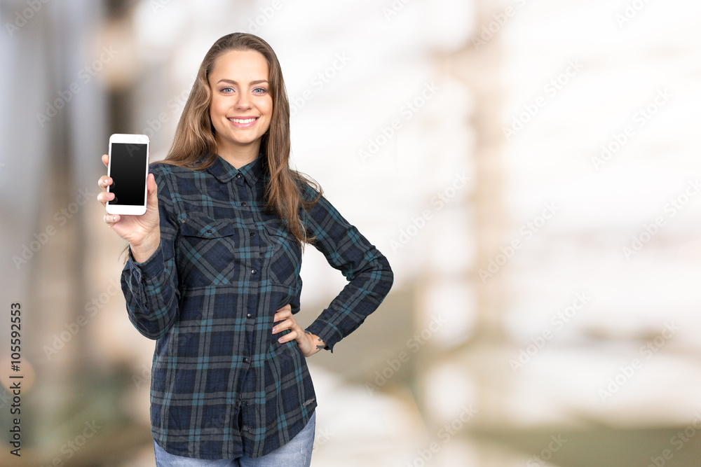Smiling young woman showing blank smartphone screen